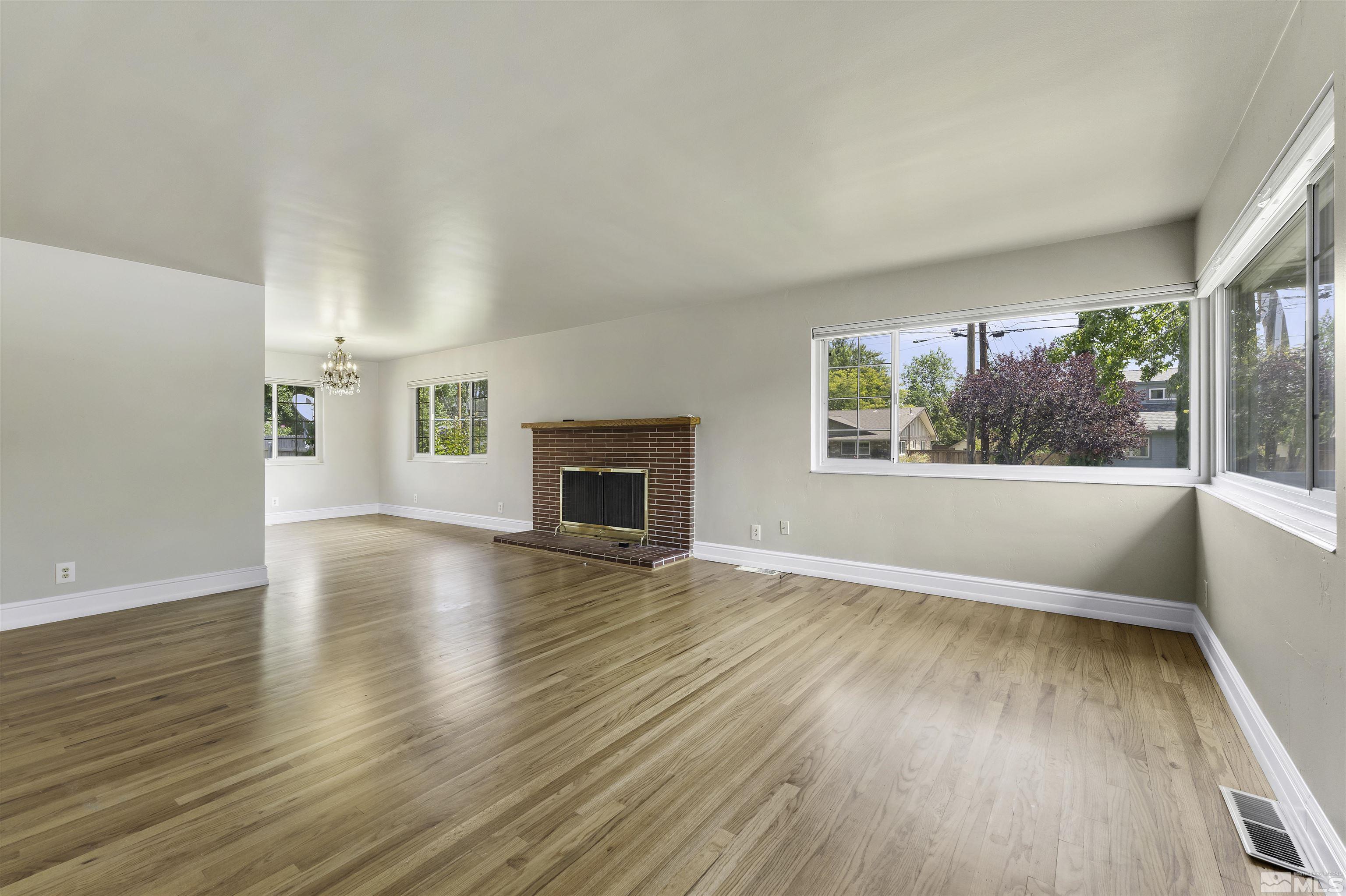 1401 Romero Way Reno, NV 89509 - Photo 10 of 28 an empty room with wooden floor fireplace and windows