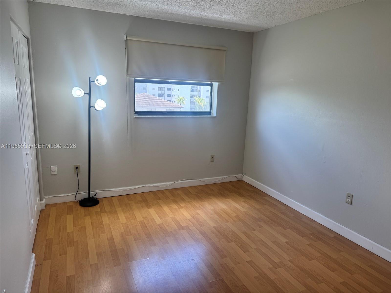 8075 Northwest 7th Street, Unit 403 Miami, FL 33126 - Photo 18 of 29 an empty room with wooden floor and windows