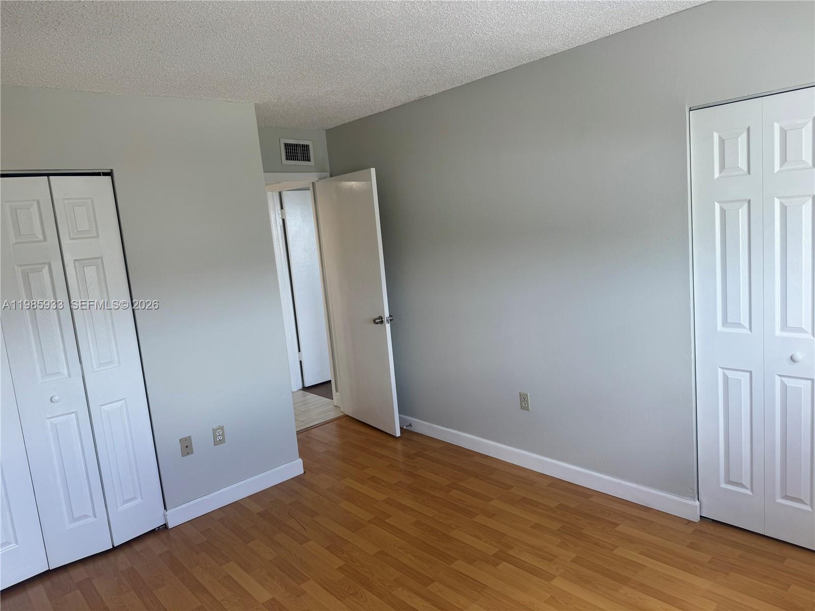 8075 Northwest 7th Street, Unit 403 Miami, FL 33126 - Photo 19 of 29 an empty room with wooden floor and entrance