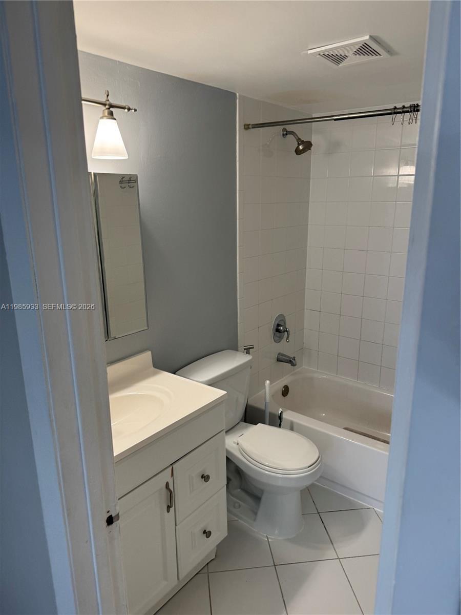 8075 Northwest 7th Street, Unit 403 Miami, FL 33126 - Photo 2 of 29 a bathroom with a granite countertop sink toilet a mirror and shower