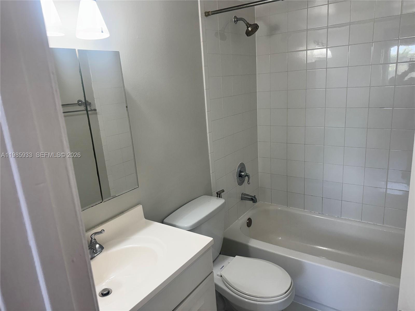 8075 Northwest 7th Street, Unit 403 Miami, FL 33126 - Photo 25 of 29 a white toilet sitting next to a bath tub