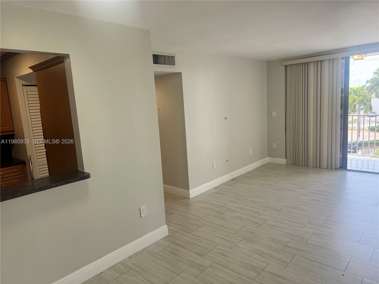 8075 Northwest 7th Street, Unit 403 Miami, FL 33126 - Photo 26 of 29 an empty room with wooden floor and a window
