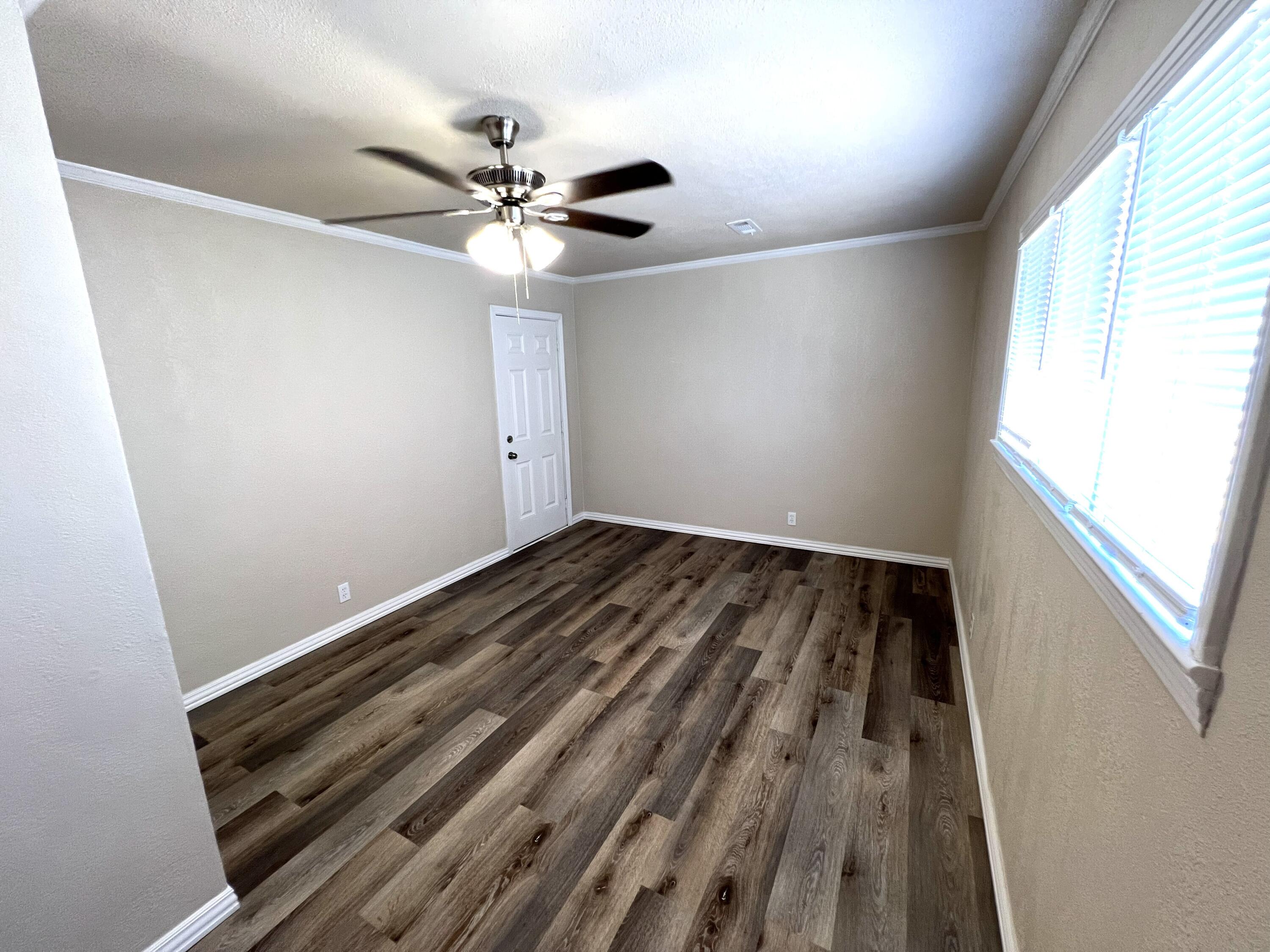 1910 64th Street Lubbock, TX 79412 - Photo 17 of 18 wooden floor in an empty room with a window