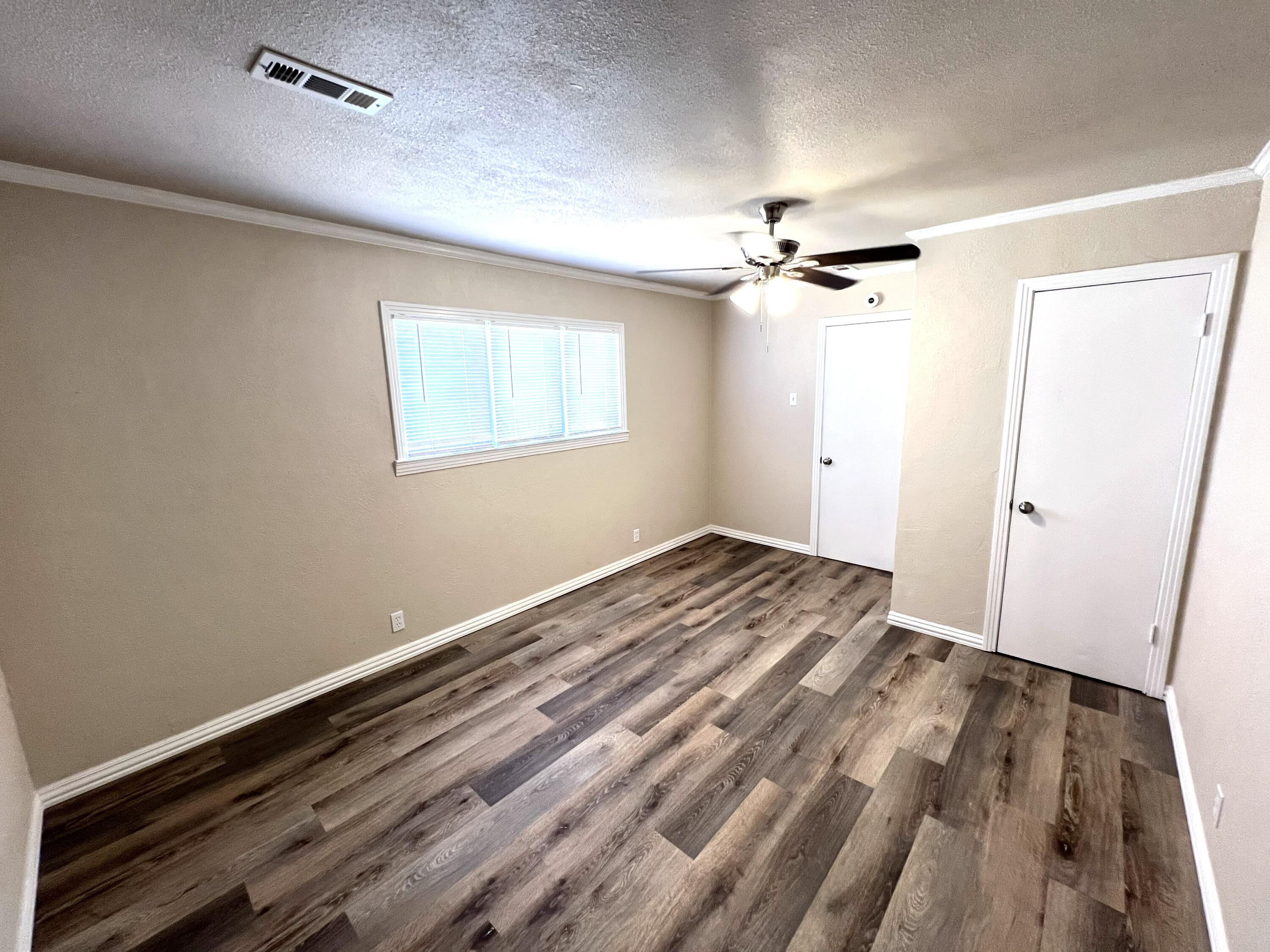 1910 64th Street Lubbock, TX 79412 - Photo 18 of 18 wooden floor in an empty room with a window