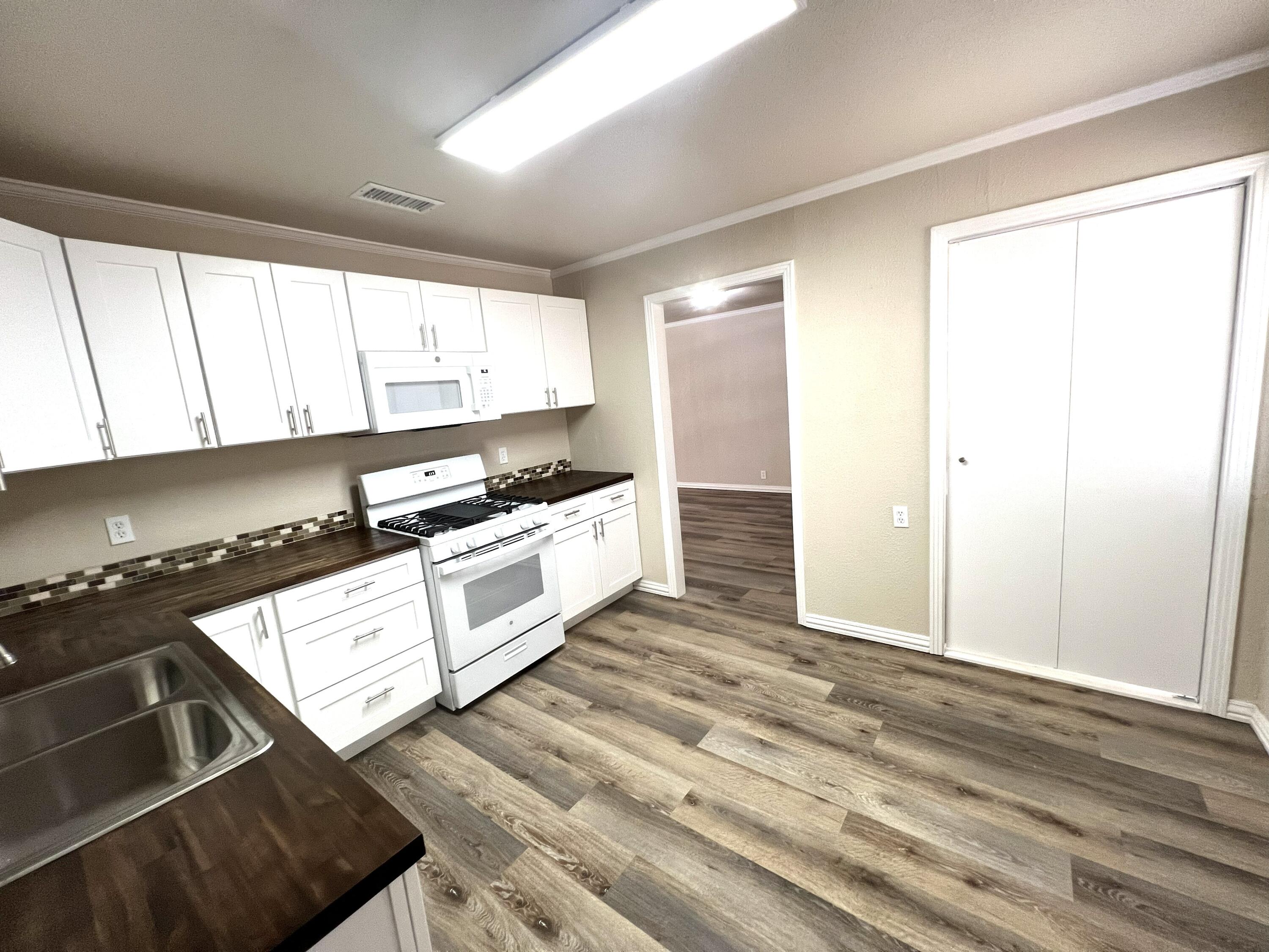 1910 64th Street Lubbock, TX 79412 - Photo 7 of 18 a kitchen with granite countertop a stove and a sink