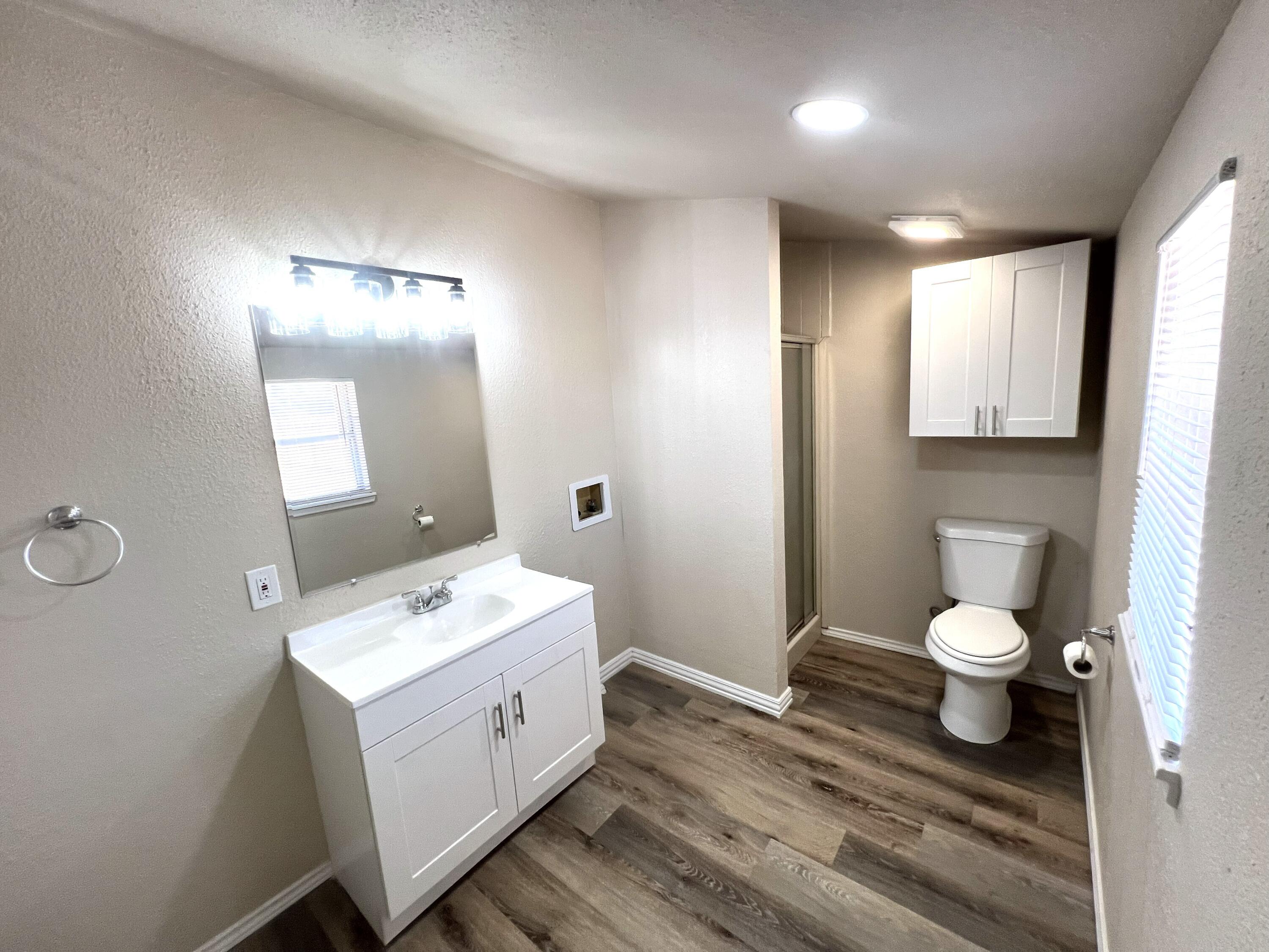 1910 64th Street Lubbock, TX 79412 - Photo 8 of 18 a bathroom with a toilet a sink and mirror