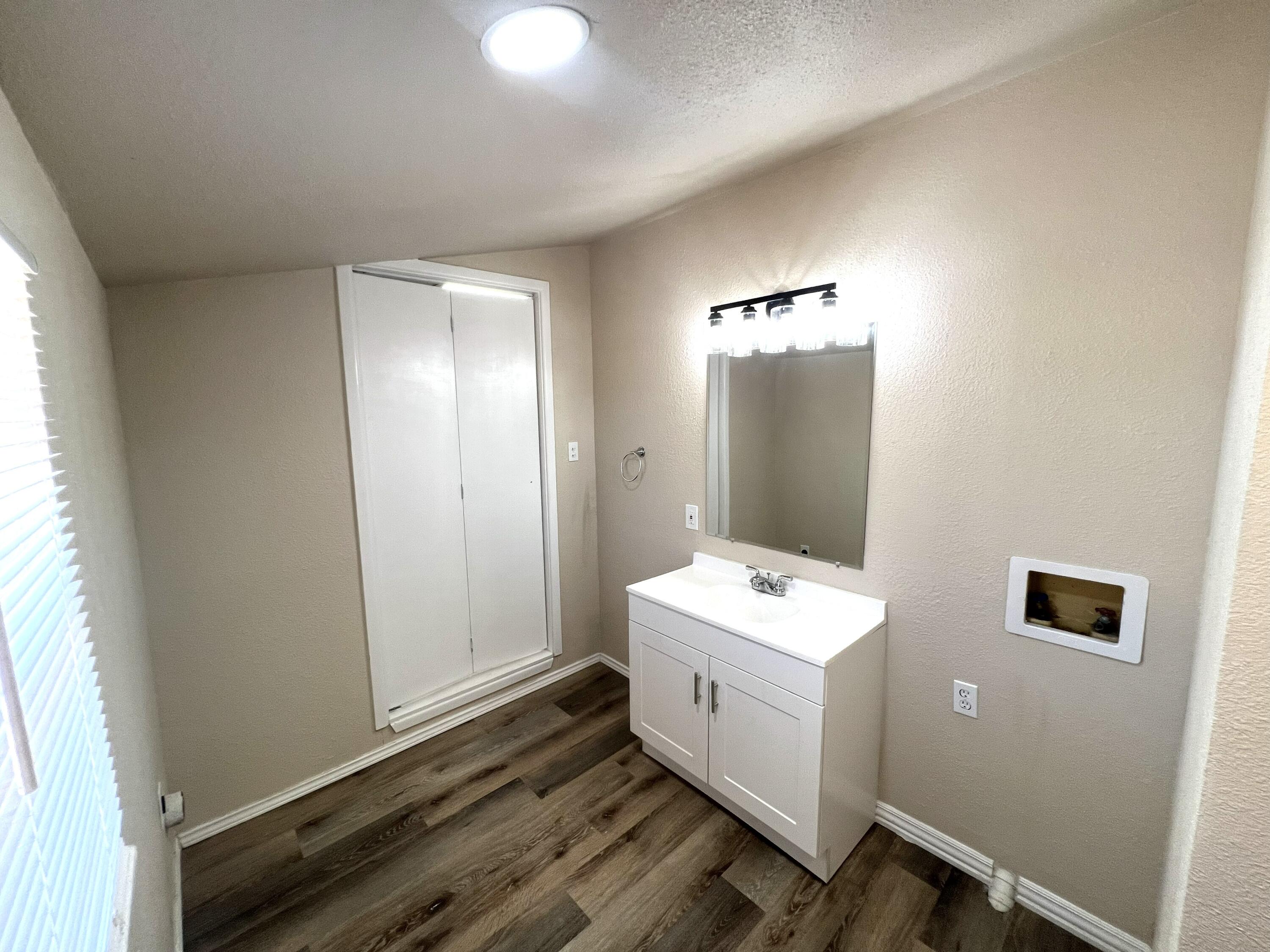 1910 64th Street Lubbock, TX 79412 - Photo 9 of 18 a bathroom with a double vanity sink and mirror