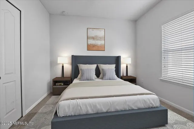 a large bed sitting in a bedroom next to a window