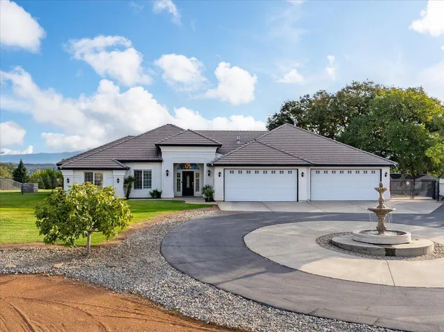 a view of a house with backyard and sitting area