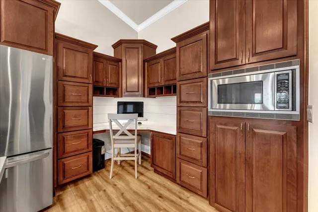 a kitchen with stainless steel appliances granite countertop a refrigerator microwave and wooden cabinets
