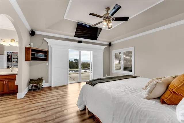 a bedroom with a bed a flat screen tv and a large window