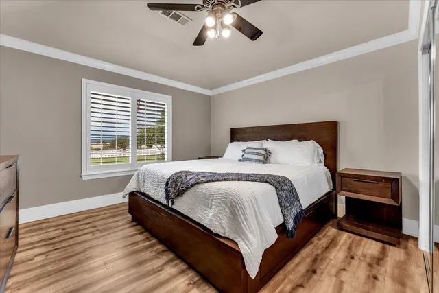 a large bed sitting in a bedroom next to a window and a chandelier
