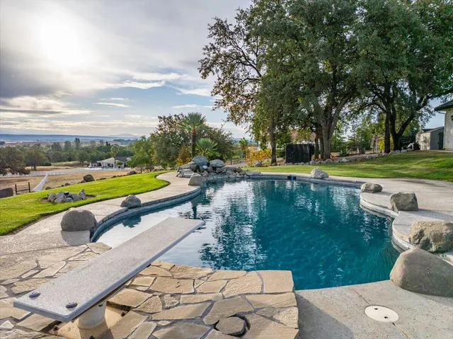a view of a lake with a yard and large trees
