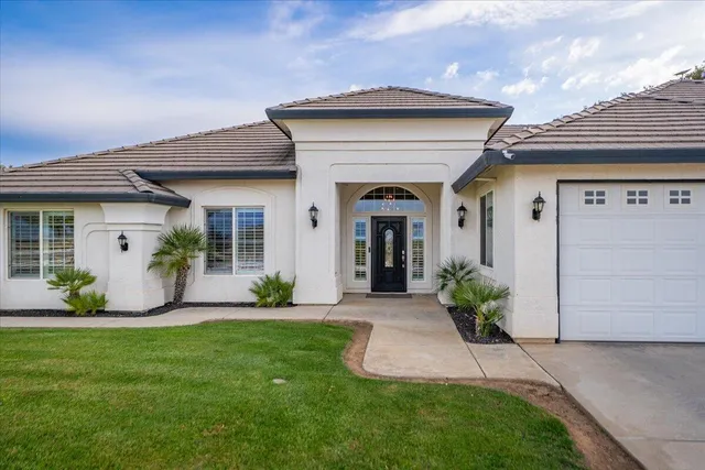 a front view of a house with a garden and plants