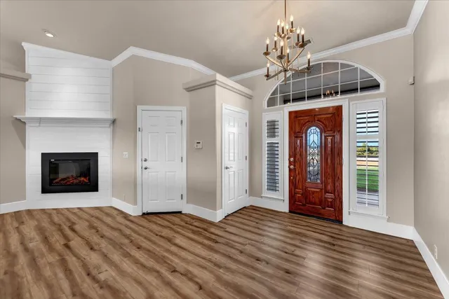 a view of a hallway with wooden floor and a fireplace