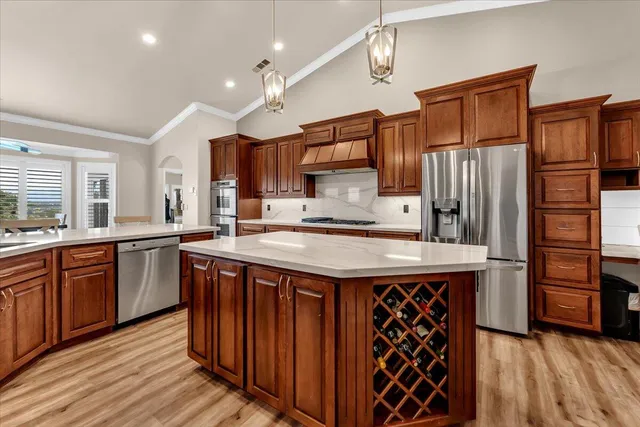 a kitchen with stainless steel appliances granite countertop a stove refrigerator and cabinets
