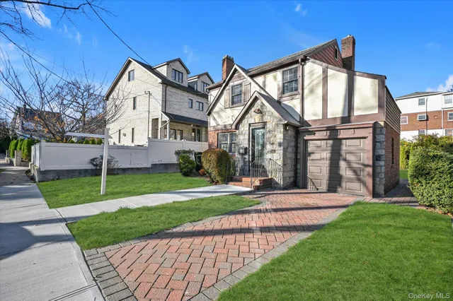 a front view of a house with a yard and trees