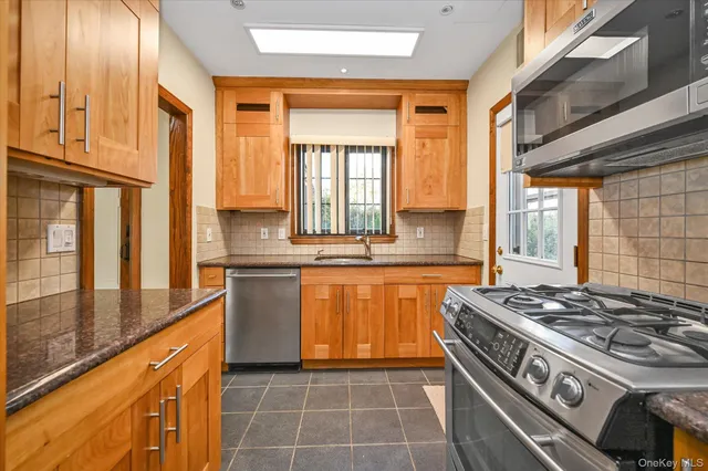 a kitchen with stainless steel appliances granite countertop a stove a sink and a refrigerator