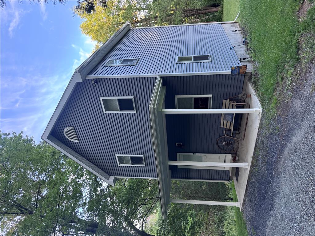 130 Hidden Spur Road Lehighton, PA 18235 - Photo 2 of 19 A charming blue home with a covered porch offers inviting curb appeal amidst natural surroundings.