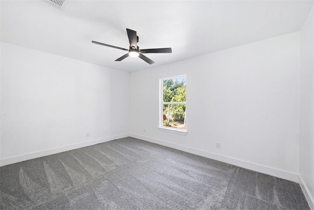 1909 Burchill Road Fort Worth, TX 76105 - Photo 15 of 18 Bright interior space featuring a window, ceiling fan with integrated lighting, and neutral carpeting