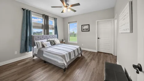 a spacious bedroom with a bed and wooden floor