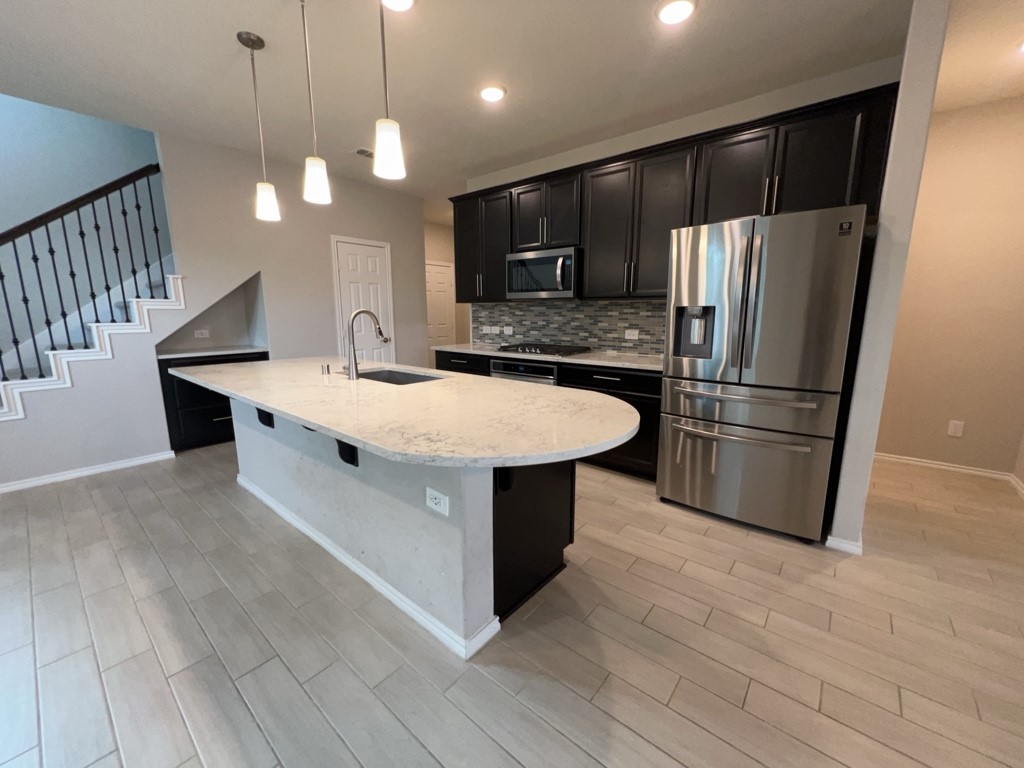 5135 Emma Forest Street Houston, TX 77018 - Photo 6 of 28 a kitchen with stainless steel appliances a sink a stove a refrigerator and island with wooden floor