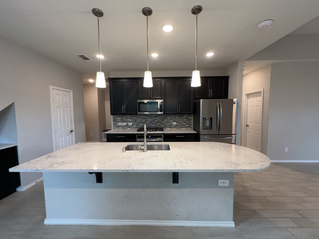 5135 Emma Forest Street Houston, TX 77018 - Photo 7 of 28 a large kitchen with kitchen island a large counter top stainless steel appliances and cabinets