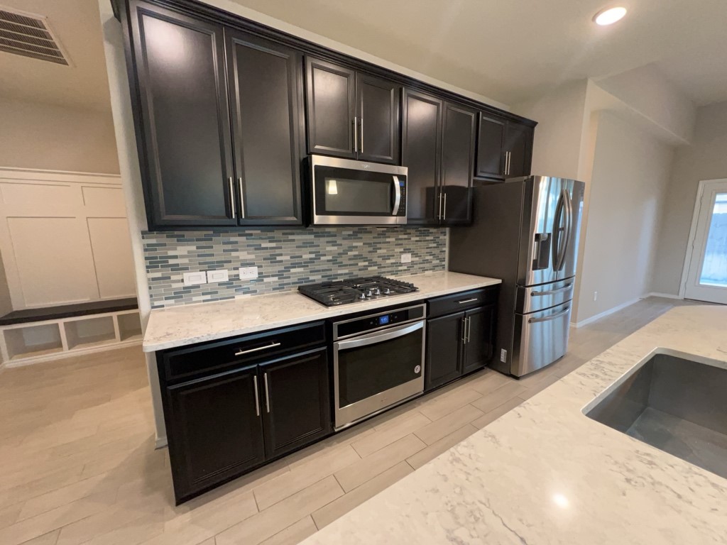 5135 Emma Forest Street Houston, TX 77018 - Photo 8 of 28 a kitchen with granite countertop stainless steel appliances and wooden cabinets
