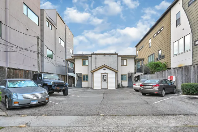 a car parked in front of a white house