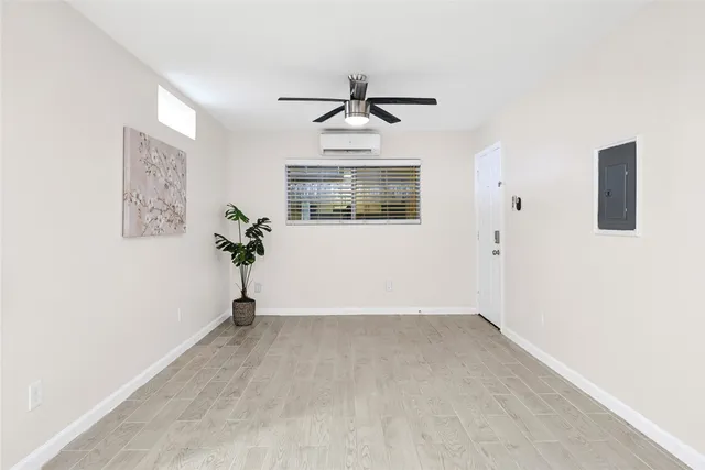 an empty room with windows and ceiling fan