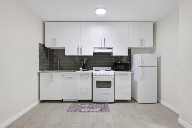 a kitchen with white cabinets and white appliances