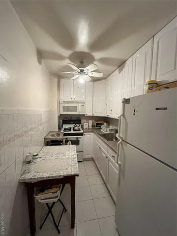 a kitchen with a sink a refrigerator and cabinets