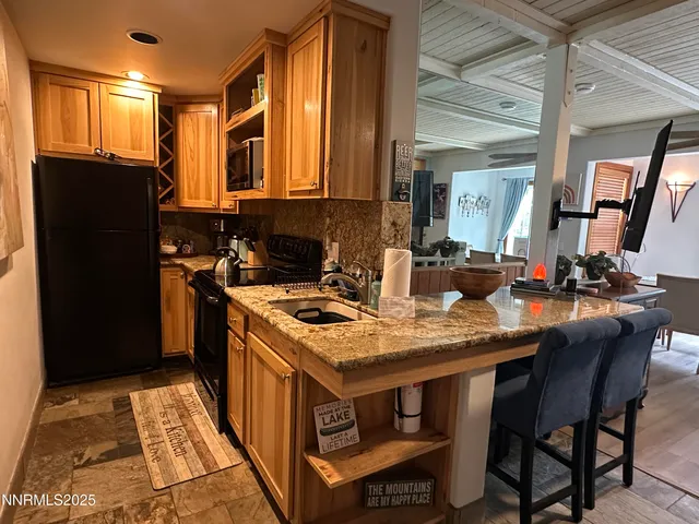 a kitchen with a stove a sink a refrigerator and a dining table