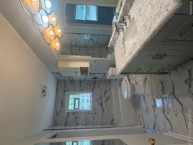 580 Palmerston Street River Rouge, MI 48218 - Photo 10 of 19 Full bathroom featuring a single vanity with a stone countertop, a built-in bathtub with a tile surround, and coordinating tile flooring