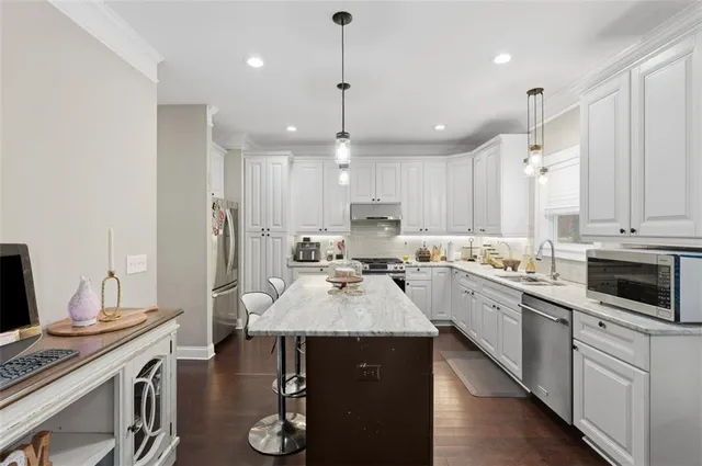 a kitchen with sink refrigerator dining table and chairs
