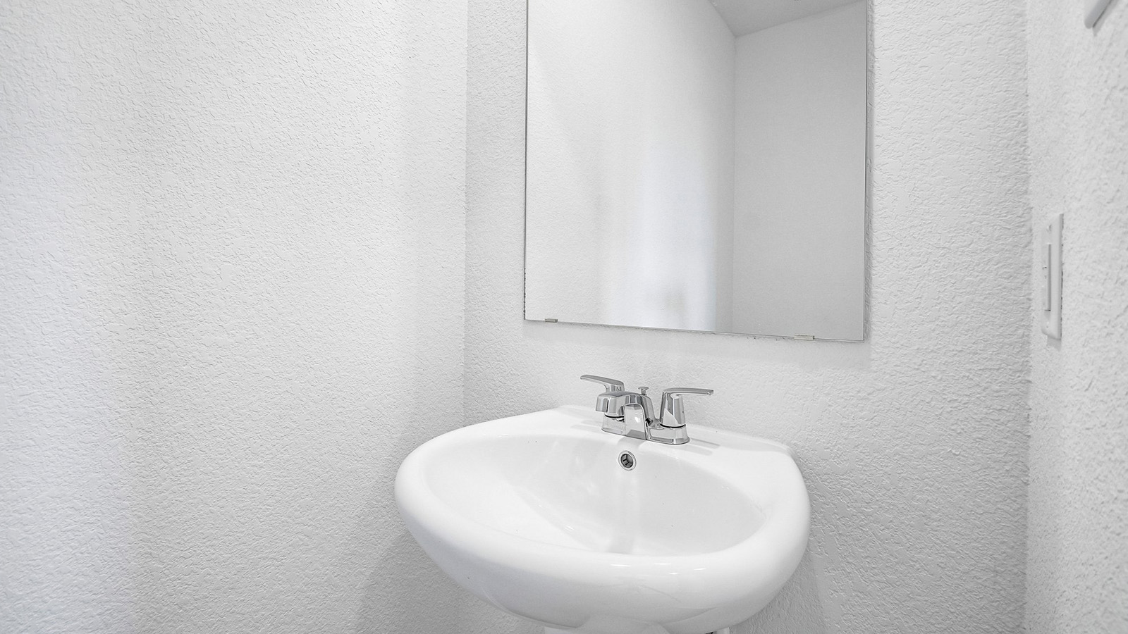 388 Old Stage Coach Road Jarrell, TX 76537 - Photo 27 of 30 A classic pedestal sink sits beneath a simple frameless wall mirror.
