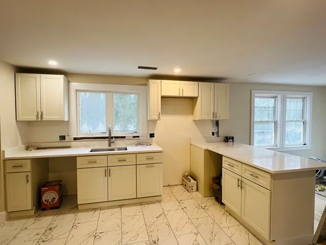 a large kitchen with a sink and cabinets