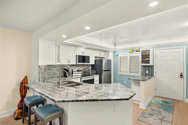 a kitchen with granite countertop kitchen island stainless steel appliances a sink and counter space