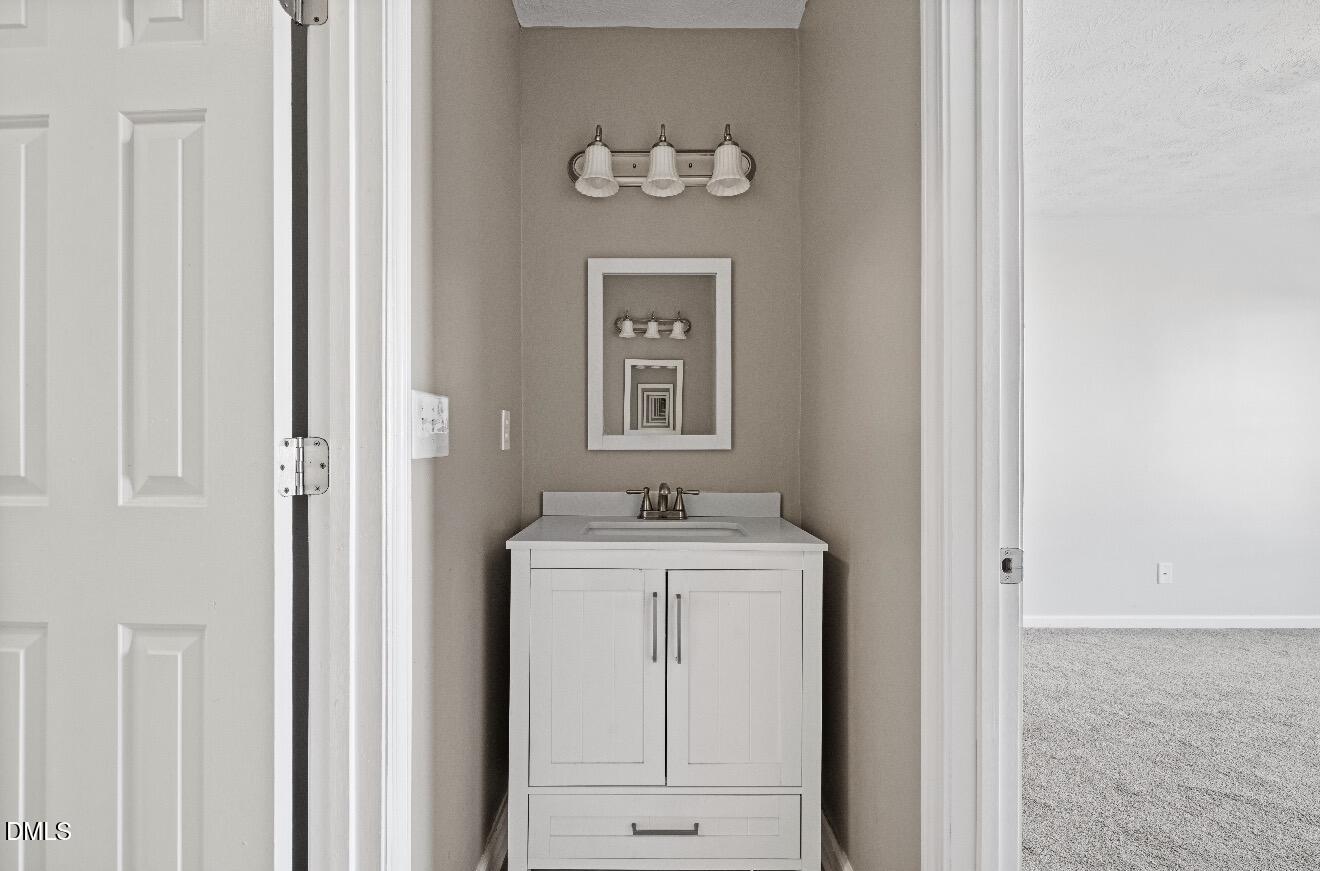 999 Flintwood Road Fayetteville, NC 28314 - Photo 18 of 23 a bathroom with a granite countertop a sink and a mirror