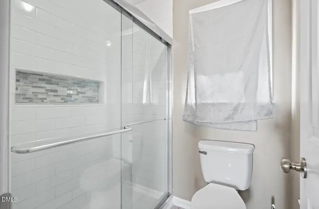 a bathroom with a toilet and a shower