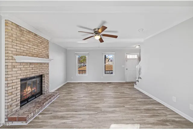 an empty room with windows and fireplace