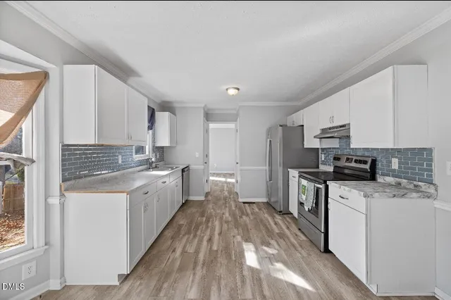 a kitchen with a sink a counter top space stainless steel appliances and cabinets