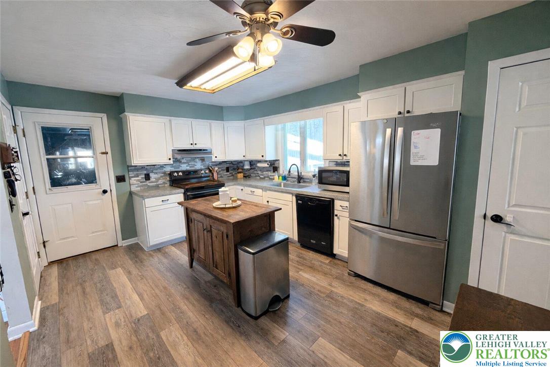 1060 Arbor Lane Slatington, PA 18080 - Photo 11 of 46 a kitchen with a refrigerator a sink dishwasher and a stove with wooden floor