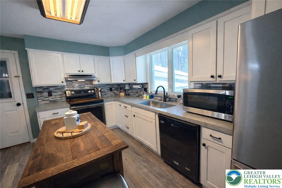 1060 Arbor Lane Slatington, PA 18080 - Photo 13 of 46 a kitchen with kitchen island granite countertop a sink appliances cabinets and a counter top space