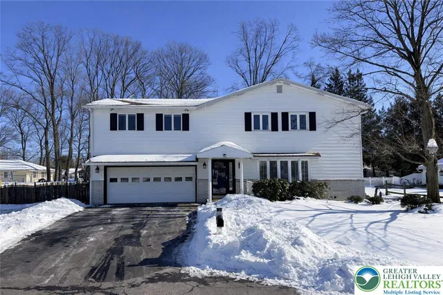 a front view of a house with a yard covered in snow