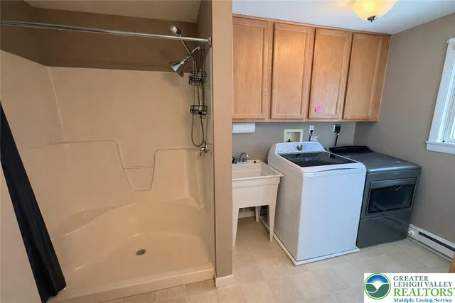 a bathroom with a granite countertop sink a mirror and a shower