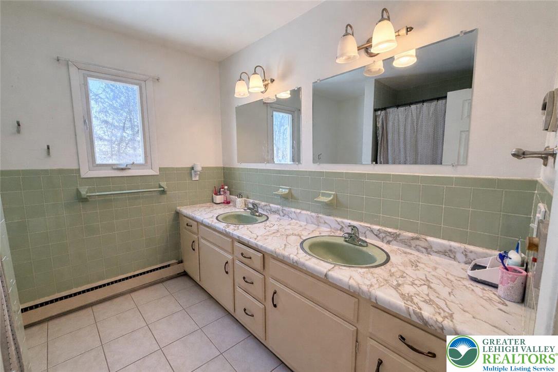 1060 Arbor Lane Slatington, PA 18080 - Photo 35 of 46 a bathroom with a granite countertop sink a large mirror and a shower