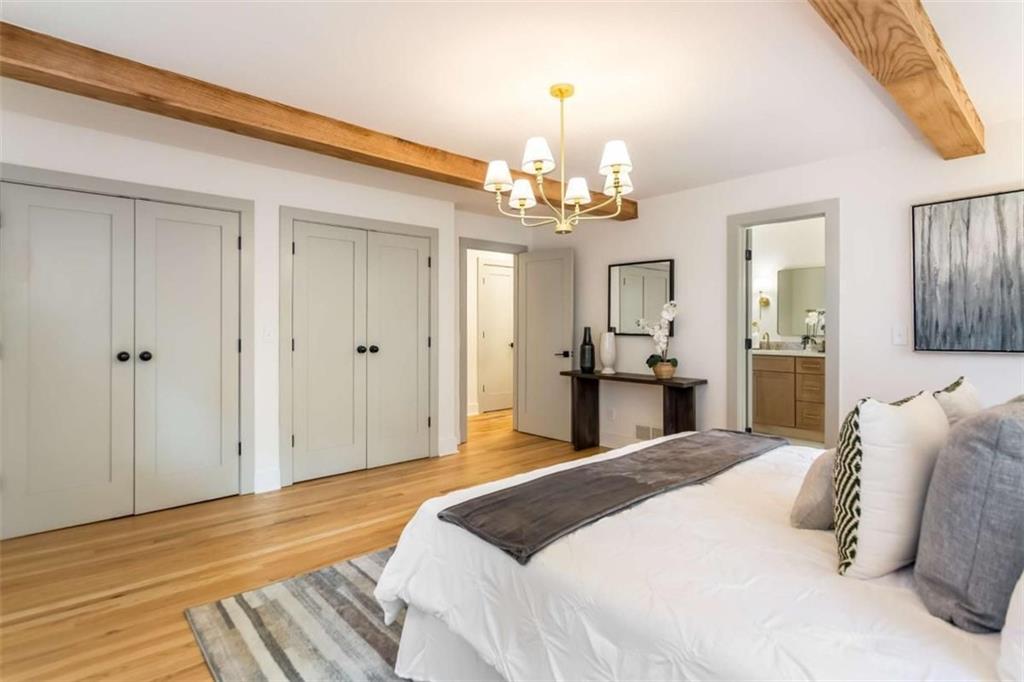 4956 Mountclaire Road Stone Mountain, GA 30087 - Photo 26 of 61 a bedroom with a large bed and chandelier