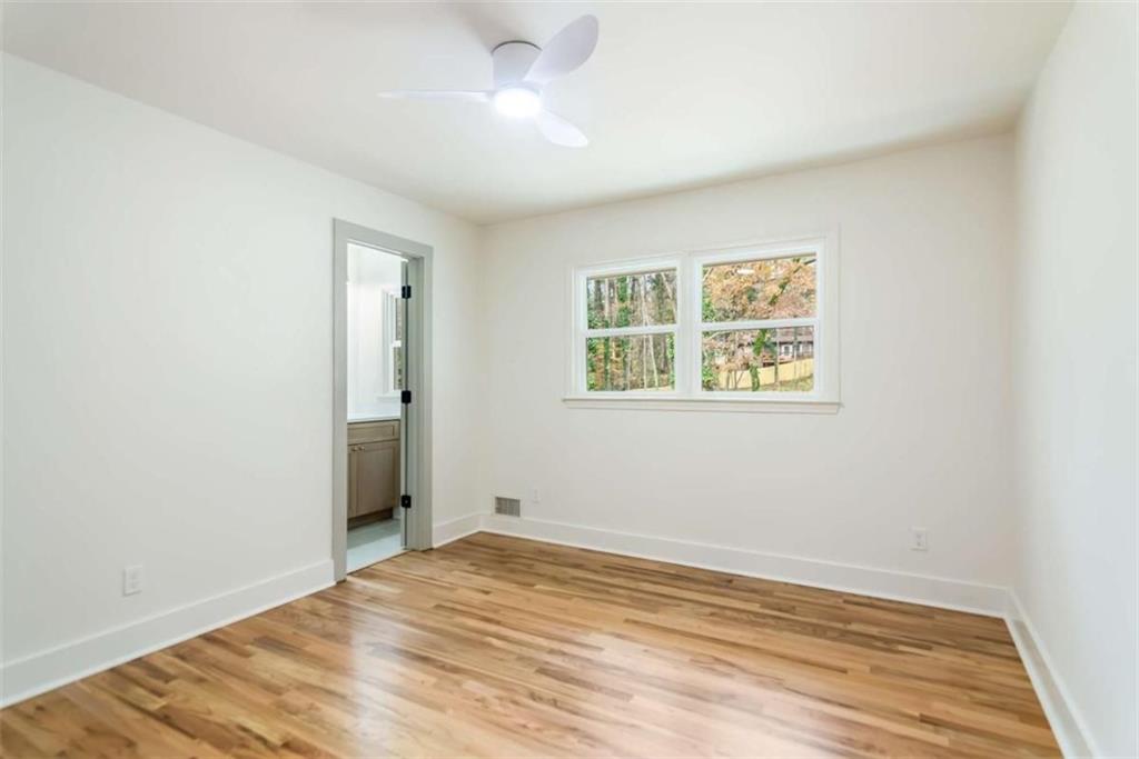 4956 Mountclaire Road Stone Mountain, GA 30087 - Photo 36 of 61 a view of empty room with wooden floor and fan