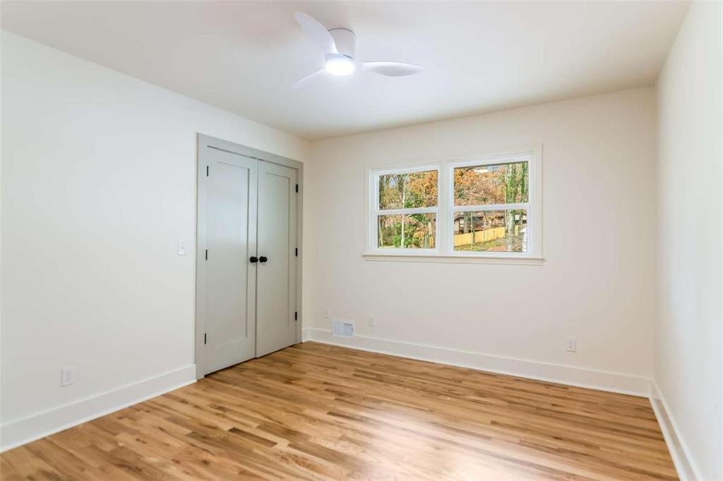 4956 Mountclaire Road Stone Mountain, GA 30087 - Photo 42 of 61 a view of empty room with wooden floor and fan